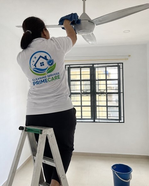 Cleaning Services Primecare cleaner dusting a ceiling fan from a ladder